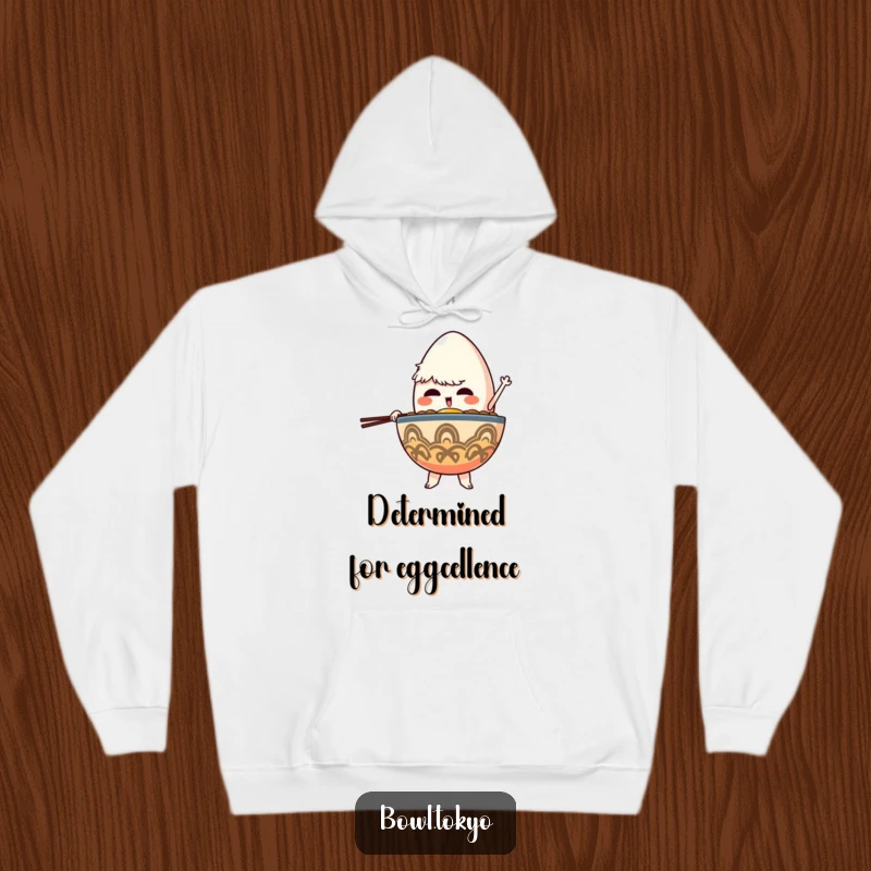 Funny Determined Ramen Bowl Hoodie featuring a character intently balancing a giant egg, combining comfort with motivational humor.