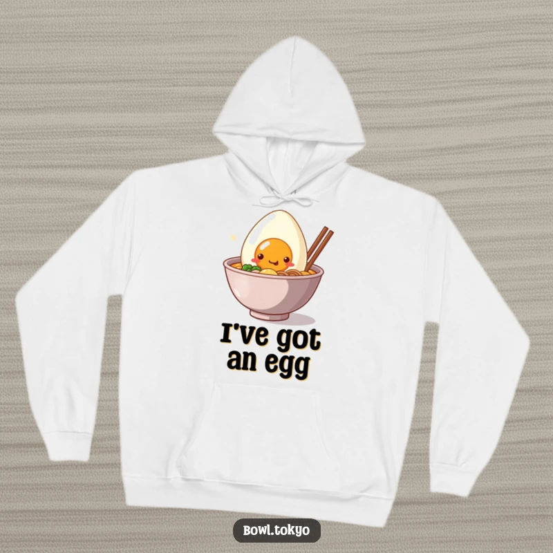 Funny Hoodie: A kawaii ramen bowl character with a giant, smiling egg peeking out, offering warmth and cuteness.