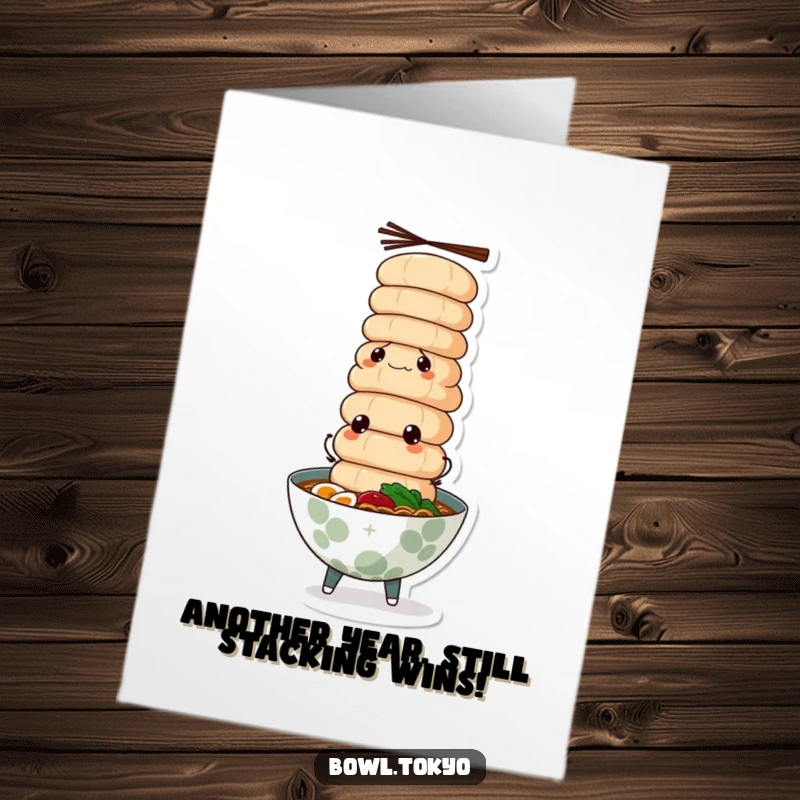 Funny Free Printable birthday card featuring a determined ramen bowl character balancing a tall tower of fish cakes.